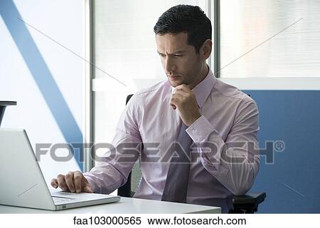 Businessman using laptop in office View Large Photo Image Stock Photography - Businessman using laptop in office. Fotosearch