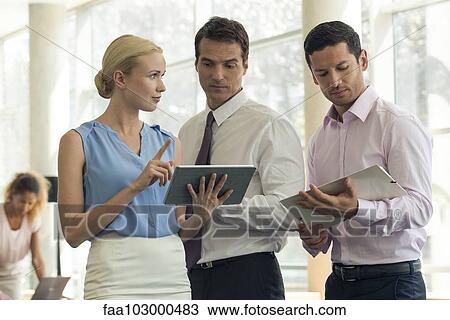 Businesswoman showing colleagues digital tablet View Large Photo Image Stock Image - Businesswoman showing colleagues digital tablet. Fotosearch