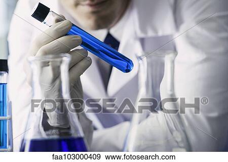 "Chemist examining test tube containing blue liquid, cropped" View Large Photo Image Stock Photo - "Chemist examining test tube containing blue liquid, cropped". Fotosearch