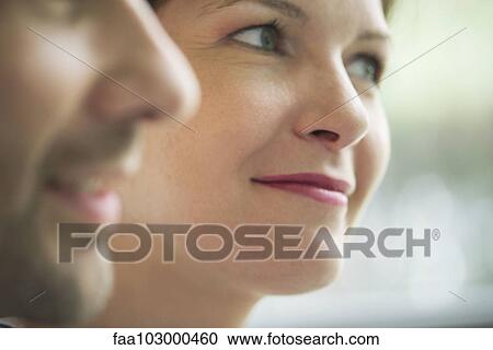 Stock Image - "Close-up of couple smiling, focus on woman". Fotosearch