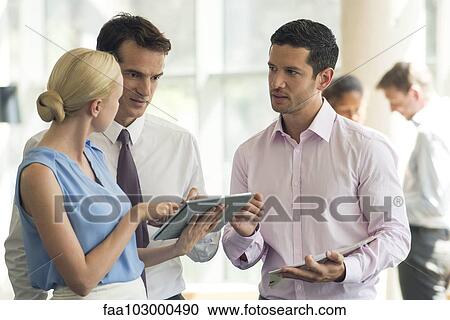Stock Image - Colleagues collaborating using digital tablet. Fotosearch