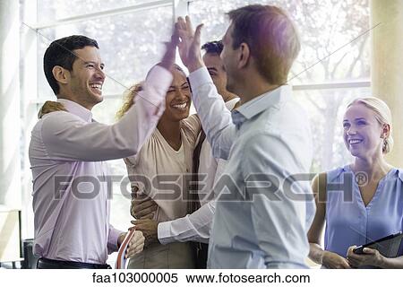 Stock Photography - Colleagues giving each other high-five. Fotosearch