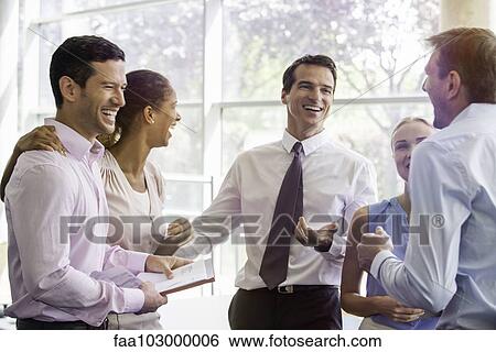 Colleagues having laugh together in office View Large Photo Image Stock Photograph - Colleagues having laugh together in office. Fotosearch