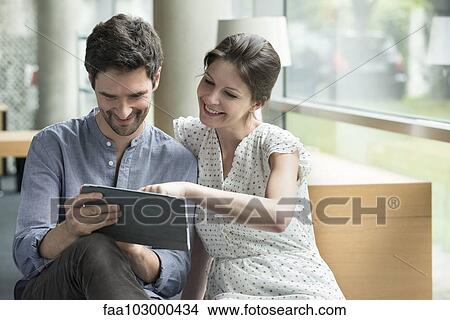 Couple using digital tablet together at home View Large Photo Image Picture - Couple using digital tablet together at home. Fotosearch