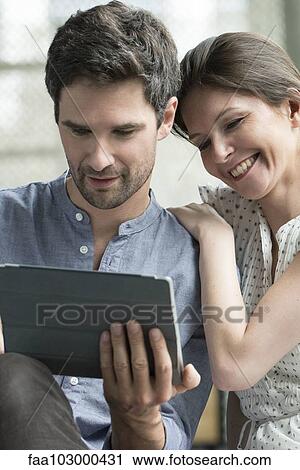 Couple using digital tablet together at home View Large Photo Image Stock Image - Couple using digital tablet together at home. Fotosearch