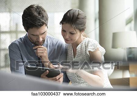 Stock Photo - Couple using digital tablet together at home. Fotosearch