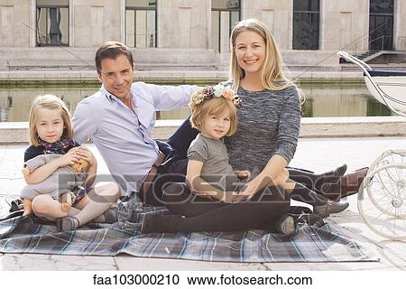 "Family sitting on blanket in urban park, portrait" View Large Photo Image Stock Image - "Family sitting on blanket in urban park, portrait". Fotosearch