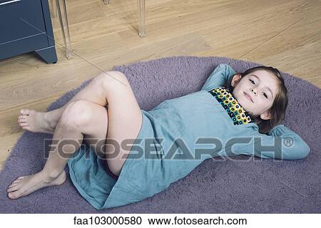 "Girl lying on floor with hands behind head, smiling" View Large Photo Image Stock Image - "Girl lying on floor with hands behind head, smiling". Fotosearch
