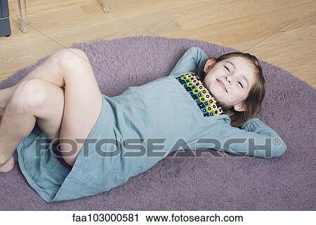 "Girl lying on floor with hands behind head, smiling" View Large Photo Image Stock Image - "Girl lying on floor with hands behind head, smiling". Fotosearch
