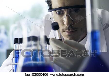 Lab technician conducting experiment in laboratory View Large Photo Image Stock Photograph - Lab technician conducting experiment in laboratory. Fotosearch