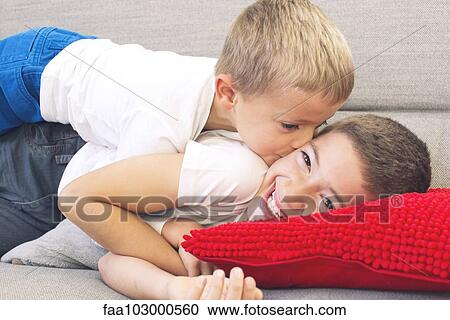 Little boy kissing his older brother's cheek View Large Photo Image Stock Image - Little boy kissing his older brother's cheek. Fotosearch