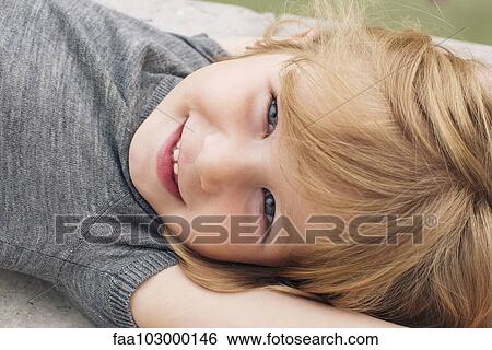 Stock Photograph - "Little girl lying on her back, smiling, portrait". Fotosearch