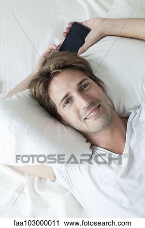 "Man relaxing on bed, portrait" View Large Photo Image Stock Image - "Man relaxing on bed, portrait". Fotosearch
