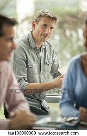 "Man sitting in cafe, smiling" View Large Photo Image Stock Photo - "Man sitting in cafe, smiling". Fotosearch