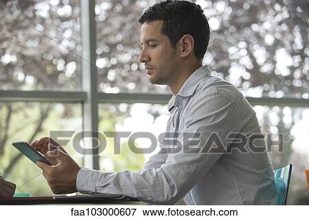 "Man using digital tablet, side view" View Large Photo Image Stock Photo - "Man using digital tablet, side view". Fotosearch