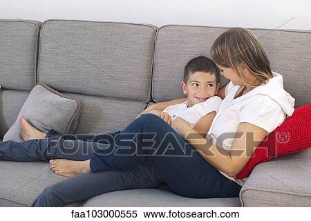 Stock Photography - Mother and son relaxing together on sofa. Fotosearch