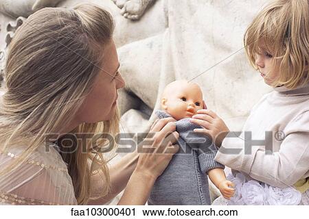 Mother and young daughter playing with baby doll together View Large Photo Image Stock Image - Mother and young daughter playing with baby doll together. Fotosearch