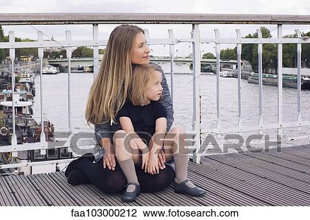 Mother and young daughter sitting together on bridge over canal View Large Photo Image Stock Image - Mother and young daughter sitting together on bridge over canal. Fotosearch