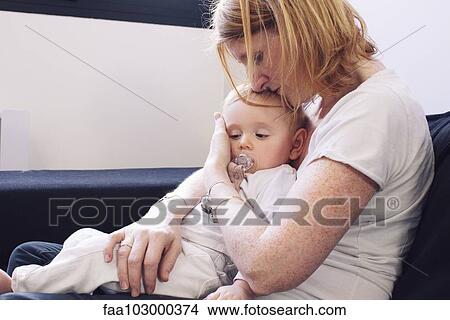 Mother holding baby on lap View Large Photo Image Picture - Mother holding baby on lap. Fotosearch