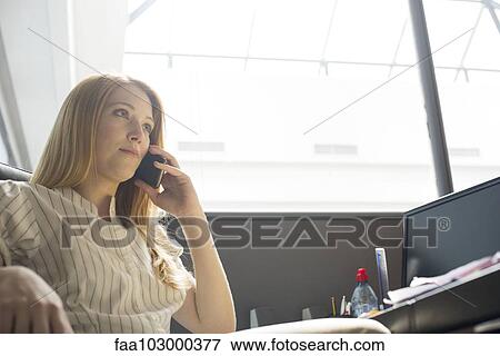 Office worker making phone call at desk View Large Photo Image Stock Photo - Office worker making phone call at desk. Fotosearch