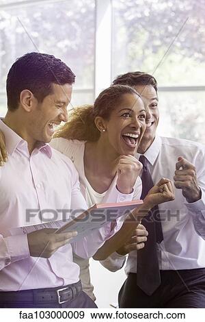 Stock Photo - Office workers sharing lighthearted moment together. Fotosearch