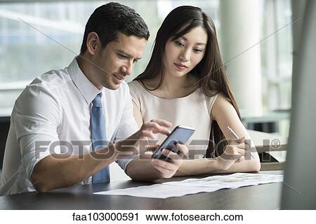 Officer worker showing colleague smartphone View Large Photo Image Stock Image - Officer worker showing colleague smartphone. Fotosearch