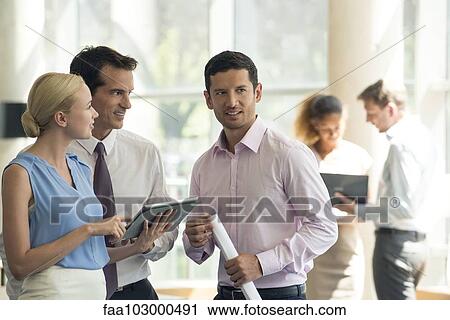 Stock Image - Professionals collaborating using digital tablet. Fotosearch