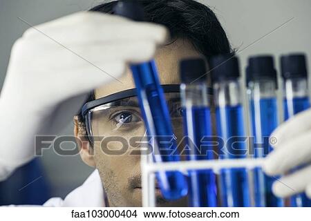 Researcher scrutinizing test tubes in laboratory View Large Photo Image Picture - Researcher scrutinizing test tubes in laboratory. Fotosearch