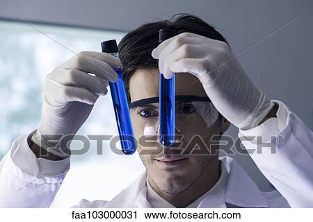 Researcher scrutinizing test tubes containing blue liquid in lab View Large Photo Image Stock Image - Researcher scrutinizing test tubes containing blue liquid in lab. Fotosearch
