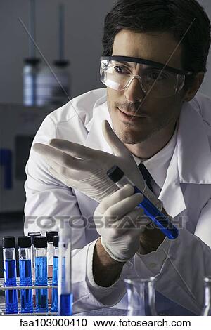 Stock Image - Scientist conducting experiment in lab. Fotosearch