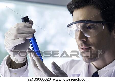 Stock Photograph - Scientist examining test tube in laboratory. Fotosearch
