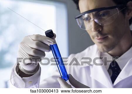 Stock Image - Scientist examining test tube. Fotosearch