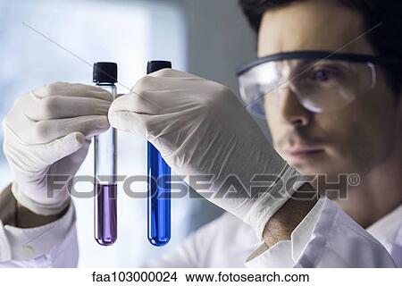 Scientist scrutinizing test tubes in lab View Large Photo Image Picture - Scientist scrutinizing test tubes in lab. Fotosearch