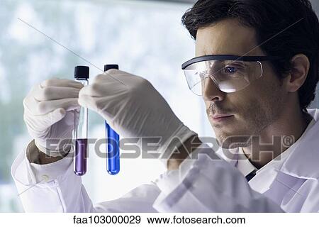 Scientist scrutinizing test tubes in lab View Large Photo Image Stock Photo - Scientist scrutinizing test tubes in lab. Fotosearch