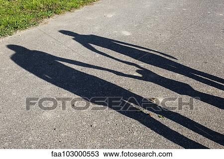 Shadow of a family holding hands outdoors View Large Photo Image Stock Image - Shadow of a family holding hands outdoors. Fotosearch