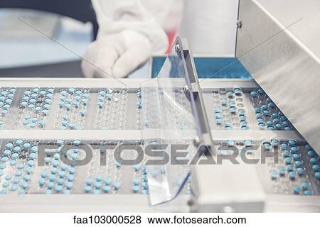 Tablet trays passing into prescription drug packaging equipment View Large Photo Image Stock Photo - Tablet trays passing into prescription drug packaging equipment. Fotosearch