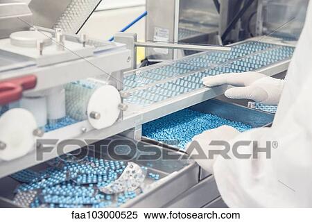 Technician operating prescription drug packaging equipment View Large Photo Image Stock Photography - Technician operating prescription drug packaging equipment. Fotosearch