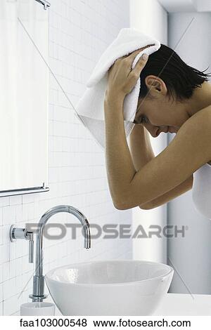 Stock Photo - "Woman in bathroom, drying hair with towel". Fotosearch