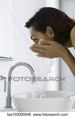 "Woman leaning over sink washing face, side view" View Large Photo Image Stock Photograph - "Woman leaning over sink washing face, side view". Fotosearch