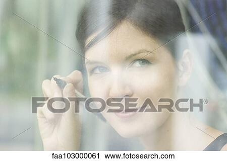 Woman preparing to write on window with marker View Large Photo Image Stock Image - Woman preparing to write on window with marker. Fotosearch