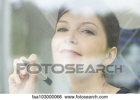 Woman preparing to write on window with marker View Large Photo Image Stock Photograph - Woman preparing to write on window with marker. Fotosearch