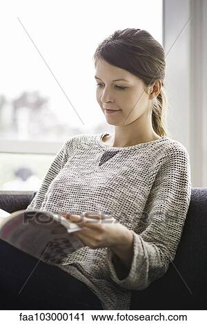 Woman reading magazine at home View Large Photo Image Stock Image - Woman reading magazine at home. Fotosearch