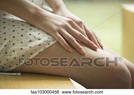 "Woman sitting with hands on bare legs, cropped" View Large Photo Image Stock Photograph - "Woman sitting with hands on bare legs, cropped". Fotosearch
