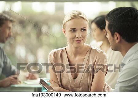 Woman smiling at male colleague during casual meeting View Large Photo Image Stock Photo - Woman smiling at male colleague during casual meeting. Fotosearch