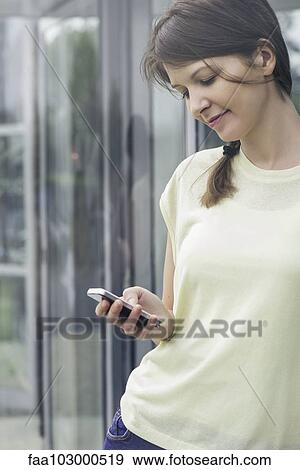 Stock Photo - Woman text messaging with smartphone. Fotosearch