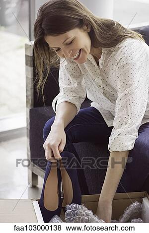 Woman unpacking box of new shoes View Large Photo Image Stock Photo - Woman unpacking box of new shoes. Fotosearch