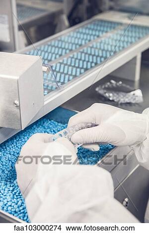 Worker emptying pills from defective blisterpacks for repackaging View Large Photo Image Picture - Worker emptying pills from defective blisterpacks for repackaging. Fotosearch