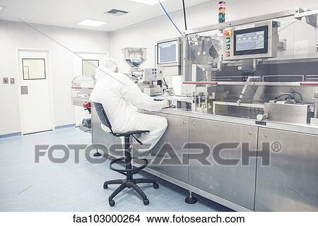 Worker operating industrial pill packing machinery View Large Photo Image Picture - Worker operating industrial pill packing machinery. Fotosearch