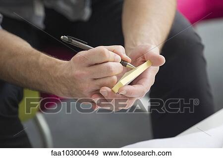 Writing note on sticky pad View Large Photo Image Stock Photo - Writing note on sticky pad. Fotosearch