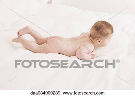 Stock Photo - Baby crawling on bed. Fotosearch